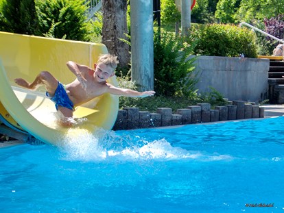 Reisemobilstellplatz - Swimmingpool - Die Wasserrutsche - das Highlight für unsere Kinder im Erlebnisbecken. Im Sportbecken kann in Ruhe geschwommen werden. - Camping am Waldbad